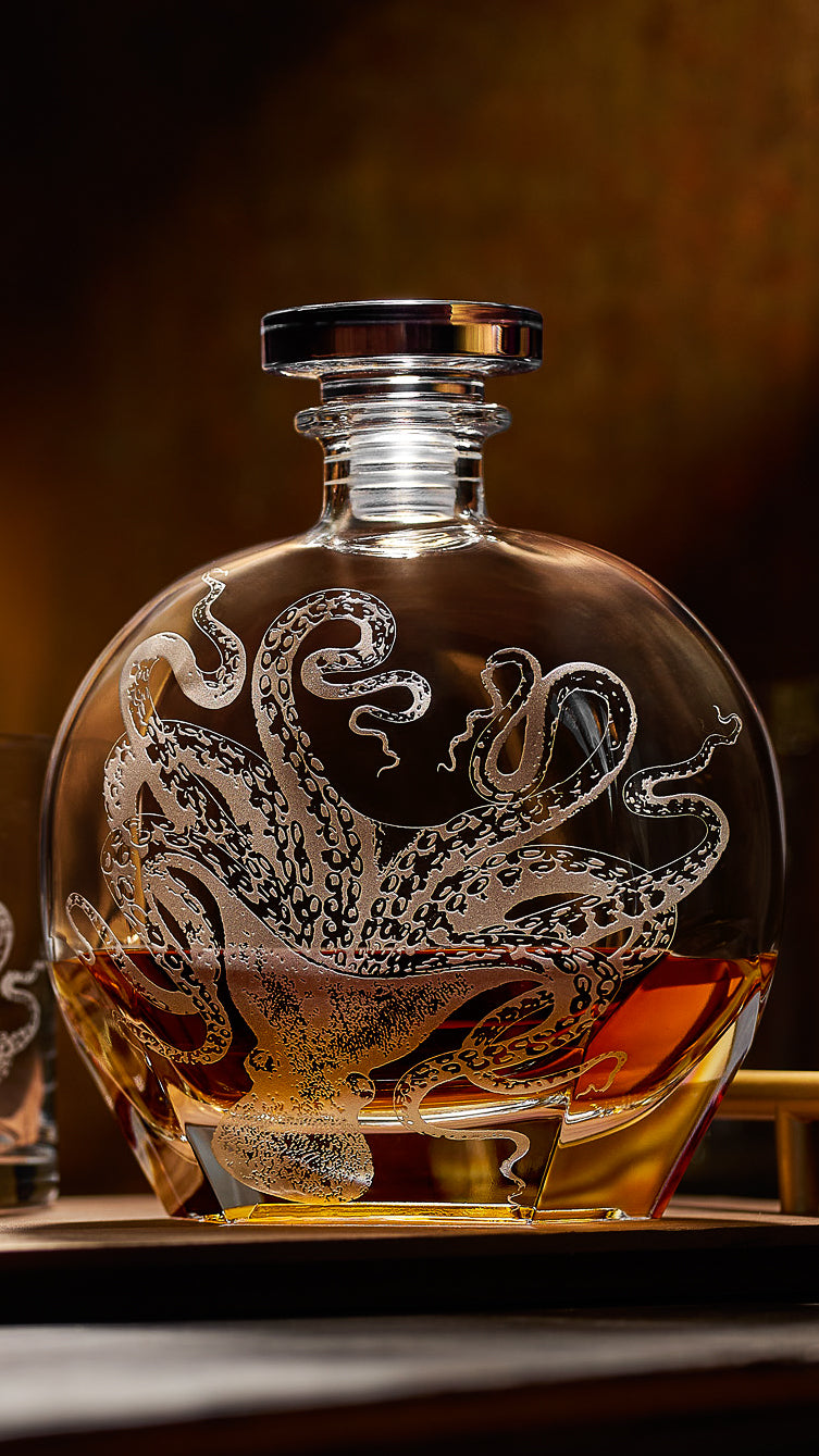 Caskata's Lucy the Octopus Crystal Etched Decanter glowing on a bar with whiskey in it