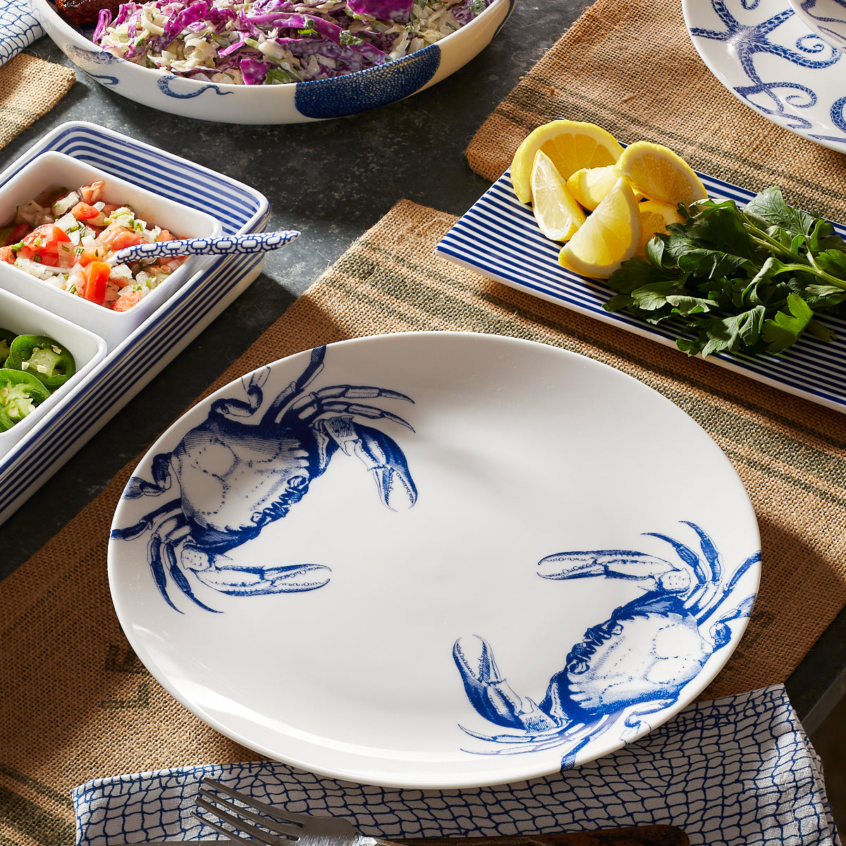 Mixed Coastal Icon Set of 4 high-fired porcelain dinner plates featuring School of Fish, Lobster, Crab, and Luy the Octopus in blue on white.