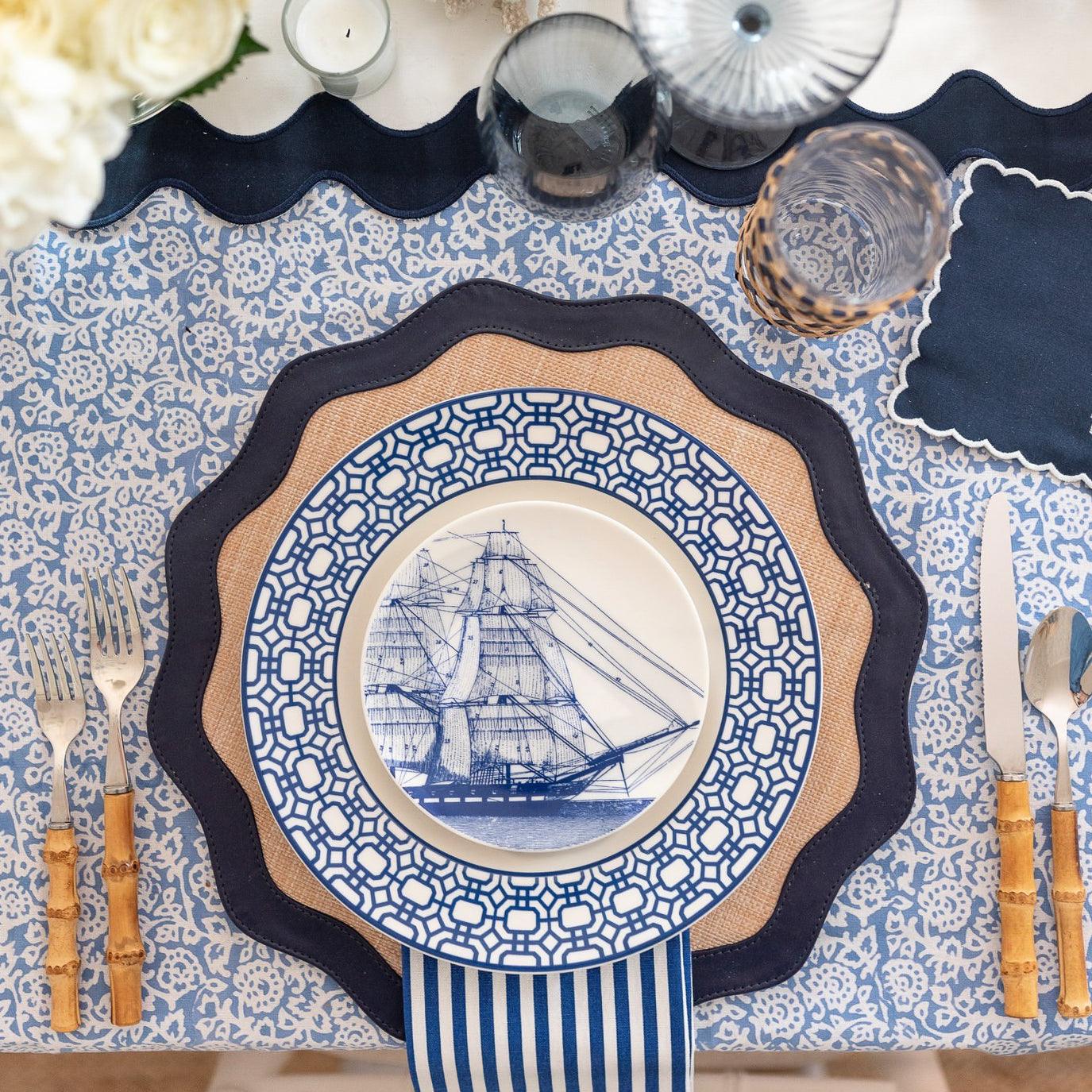 Four Rigging Small Plates from Caskata Artisanal Home featuring a blue and white design of a sailing ship, each piece showcasing vintage illustrations that form a complete image of the vessel, perfect for those who appreciate heirloom-quality dinnerware.