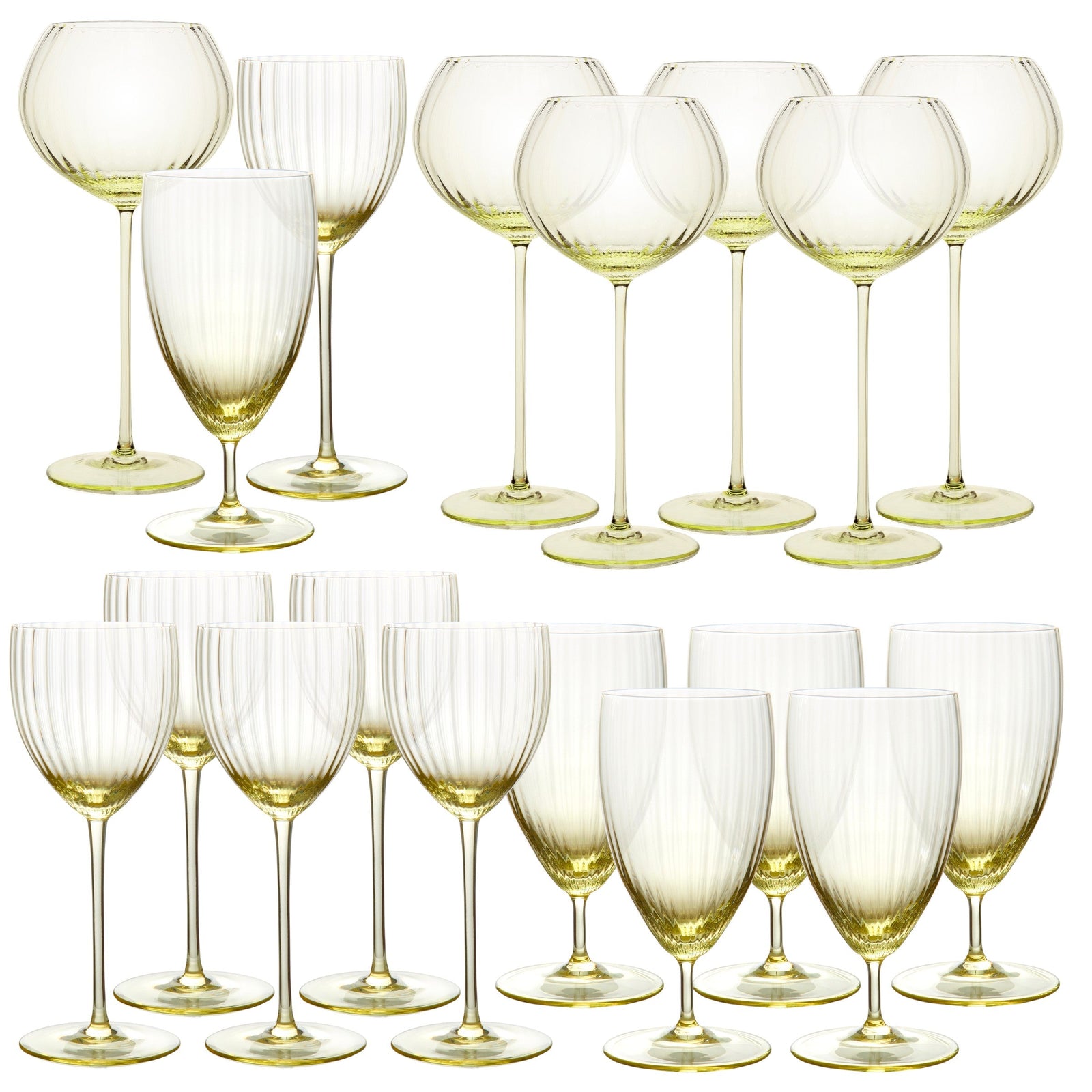 The Quinn Citrine Perfect Place Settings Set by Caskata features sixteen mouth-blown crystal wine glasses with light yellow-tinted stems and bowls, beautifully arranged in two rows against a white background.