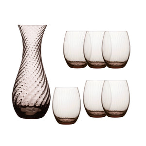 The Quinn Mocha Dinner Party Set by Caskata features a textured glass carafe and six ribbed crystal glasses in a light brown tint, creating an elegant display on a white background.