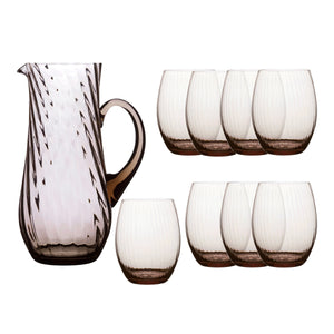 The Quinn Mocha Sangria Set by Caskata features a clear, mouth-blown crystal pitcher with a handle and six matching textured stemless glasses, all crafted in the Czech Republic.