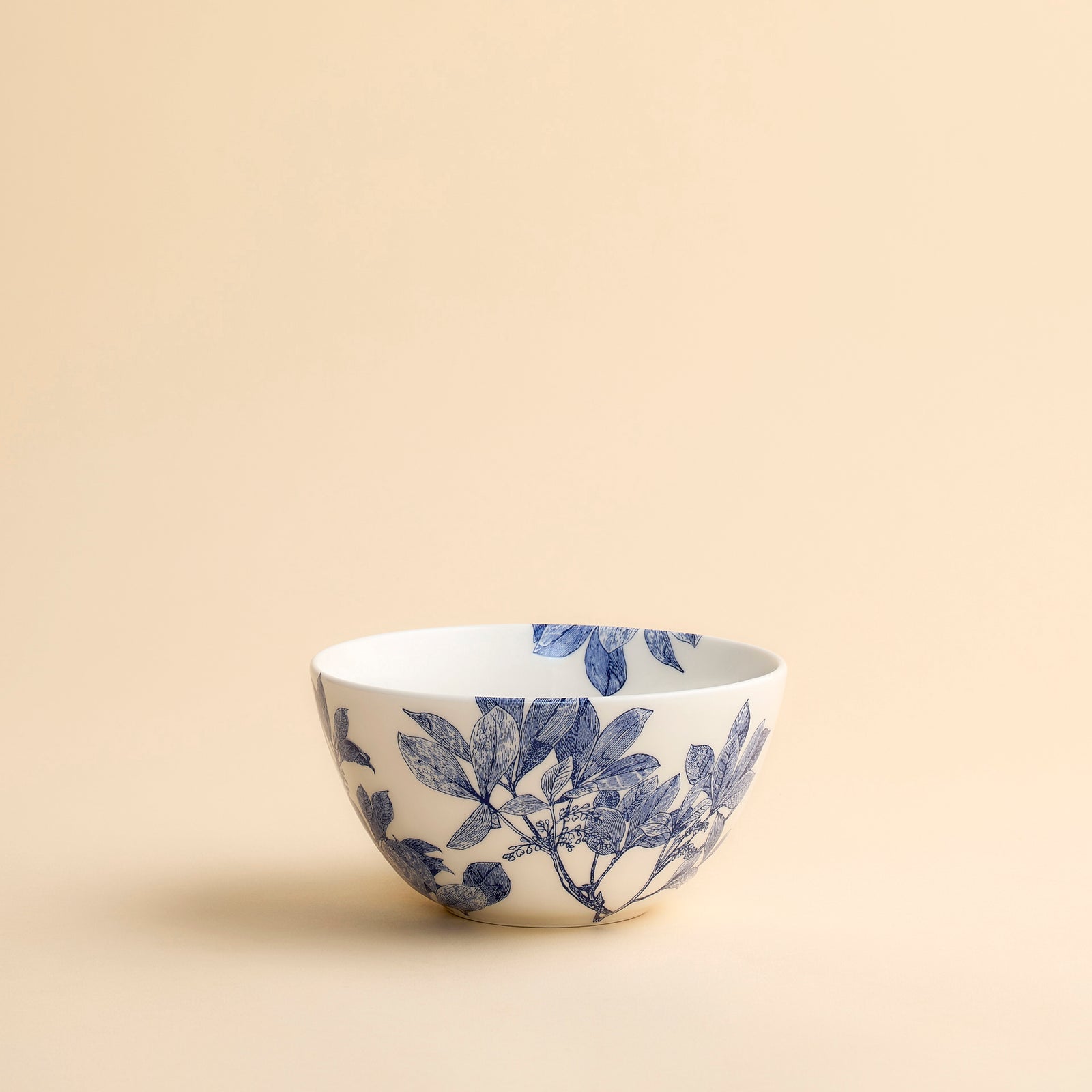 Pretty Arbor blue and white cereal sized bowl showcases floral engravings in a contemporary scale on this porcelain bowl from Caskata