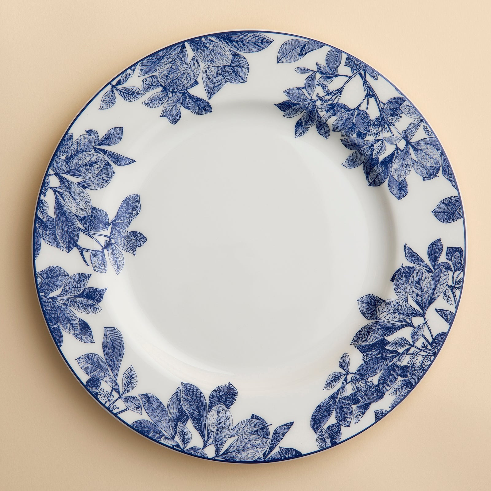 Blue and white floral engravings rim this Arbor porcelain dinner plate from Caskata.