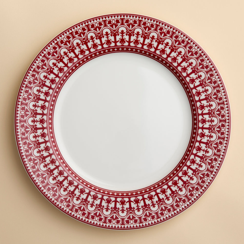 RIch crimson red in the Casablanca pattern circles this rimmed porcelain dinner plate from Caskata