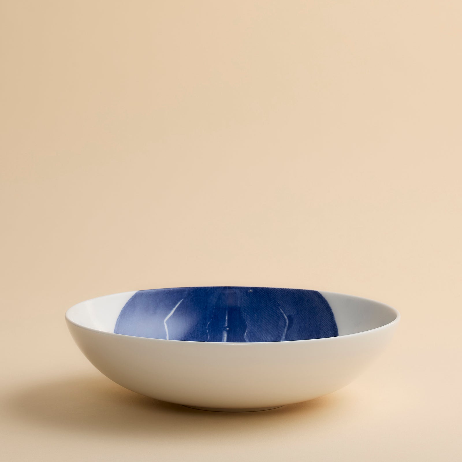 Caskata’s Horseshoe Crab Entrée Bowl—a white oval plate adorned with a blue horseshoe crab illustration viewed from above—adds exquisite coastal charm and seaside elegance to any table setting.