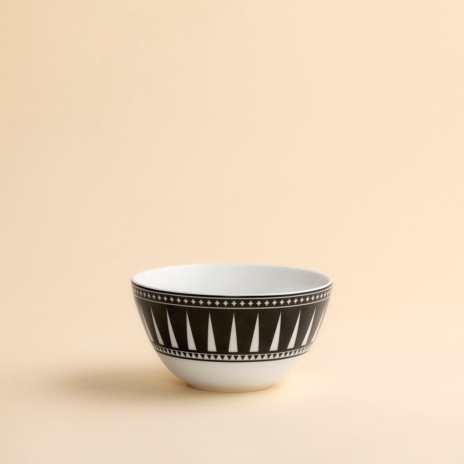 Marrakech cereal bowl shown in profile with a striking black and white geometric pattern on creamy white porcelain from Caskata