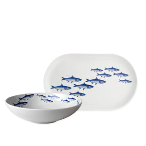 The Caskata School of Fish Serving Set features a white porcelain bowl and platter, each decorated with blue fish—a perfect choice for adding a coastal vibe to your kitchen.
