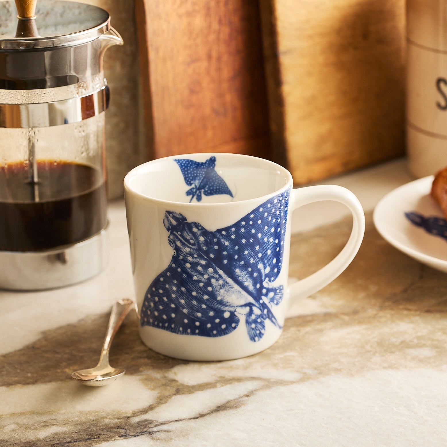 The Caskata Ray of Sunshine Bundle features a blue manta ray mug, blue & white polka dot wrapping paper, ribbon, gift tag, folded tissue paper, and a Sea Stripe Cocktail Napkin Roll—perfect for ocean-inspired gifting.