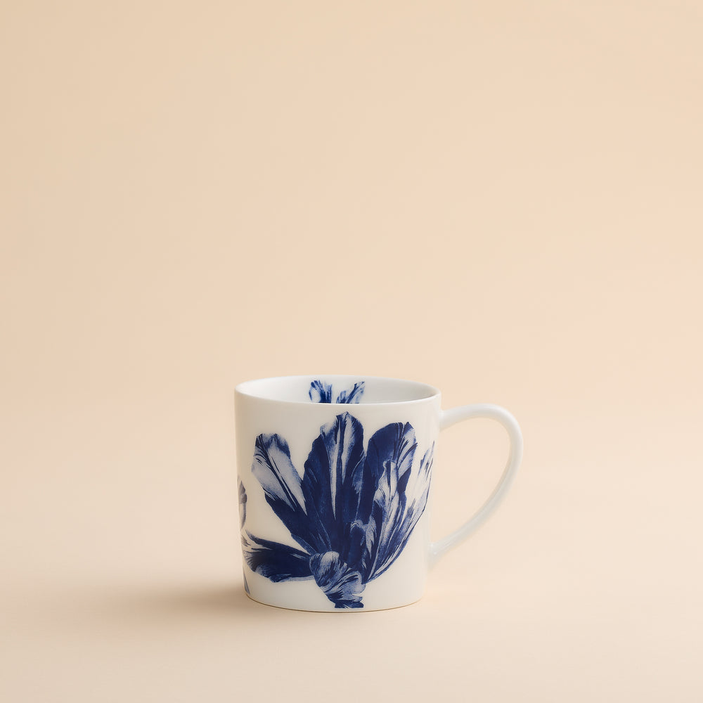 Caskata Tulip Mug, a white porcelain coffee mug decorated with a large, dark blue botanical pattern.