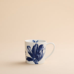 Caskata Tulip Mug, a white porcelain coffee mug decorated with a large, dark blue botanical pattern.