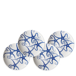 Four white ceramic starfish plates featuring blue starfish designs arranged in a circular pattern, crafted from porcelain and heirloom-quality dinnerware, called the Starfish Small Plates by Caskata Artisanal Home.